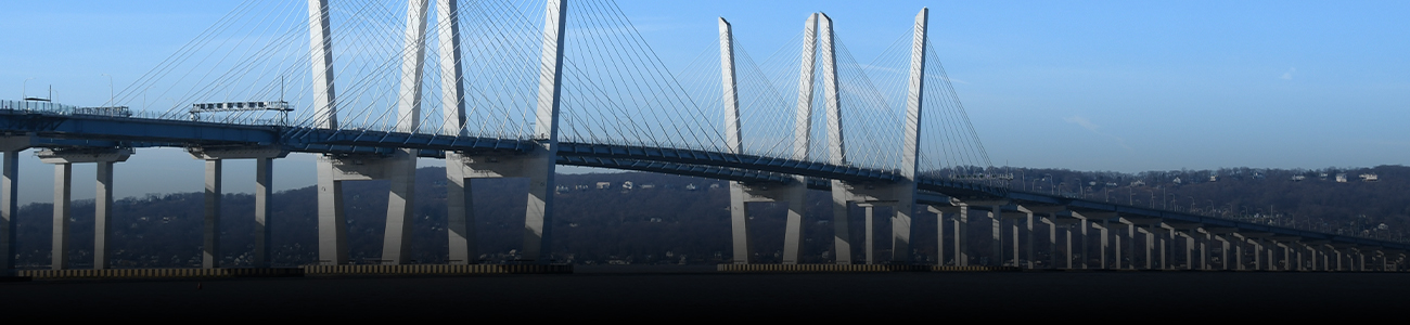 Modern cable-stayed bridge over a calm river with clear skies.