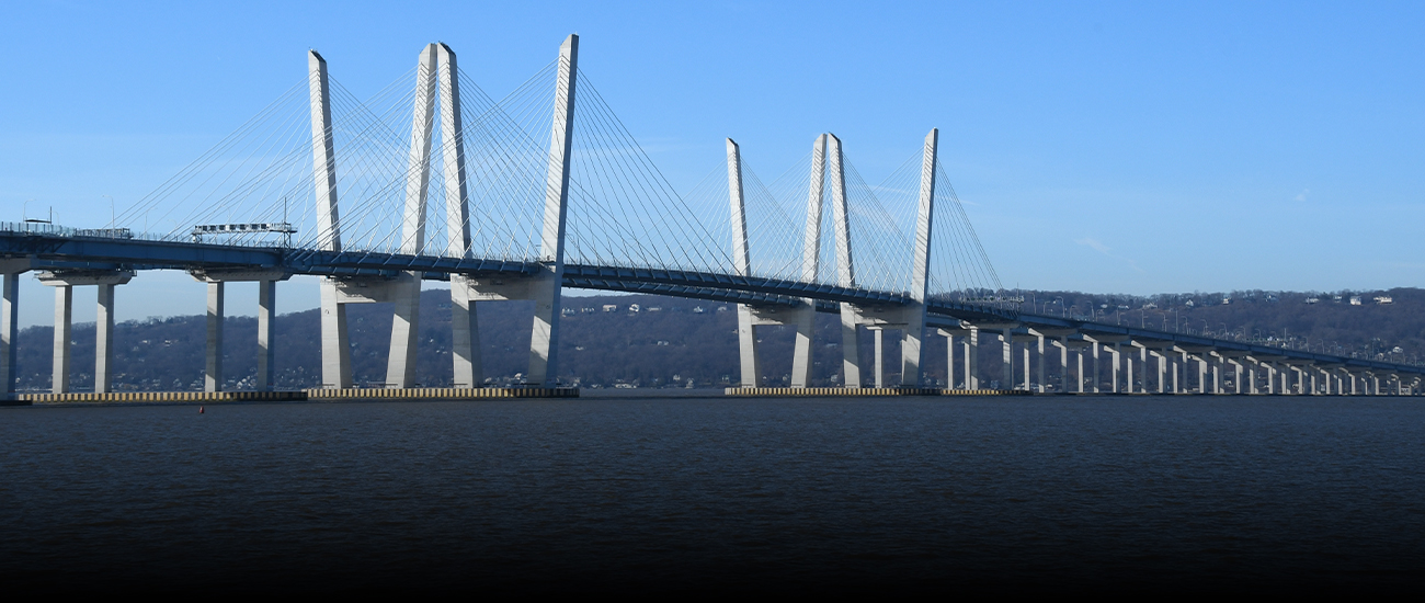 Modern cable-stayed bridge over a calm river with clear skies.